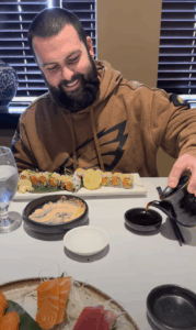 Colby pouring soy sauce for sushi during lunch