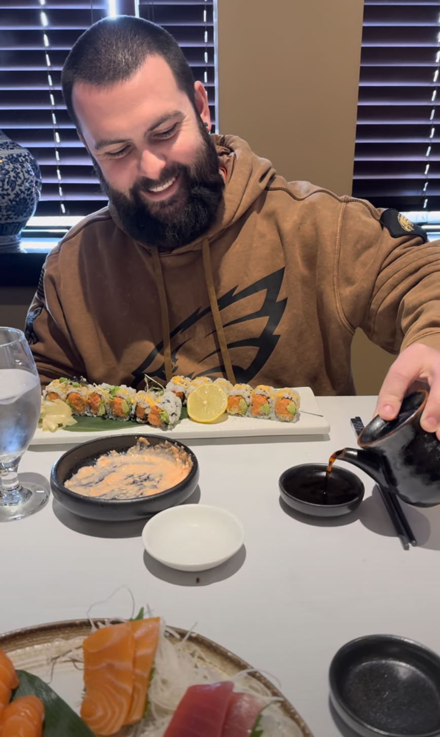 Colby pouring soy sauce for sushi during lunch